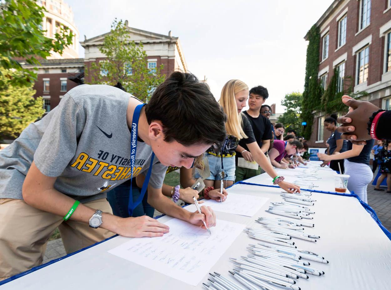 Students sign the class roll as part of a tradition at the University of Rochester